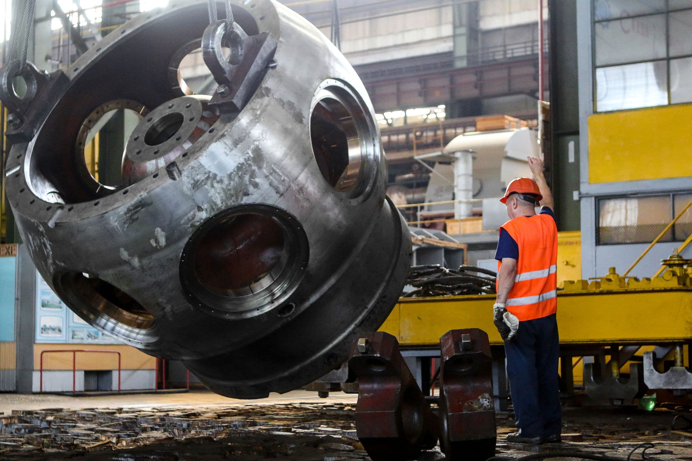 Heavy steam equipment being rigged inside a power plant hall, the systems ICPE analyzes and designs.