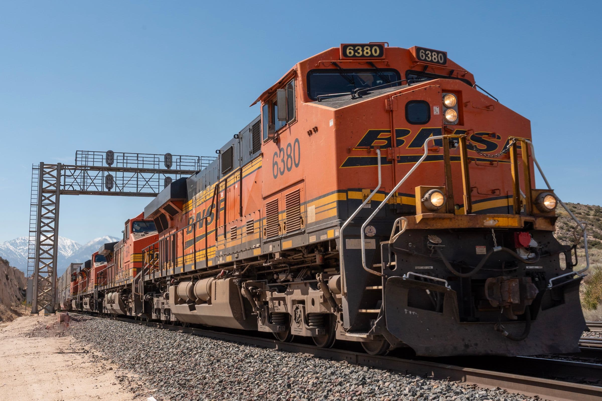 Freight locomotives leading railcars through mountain terrain, the rail side of the transloading operations ICPE designs.