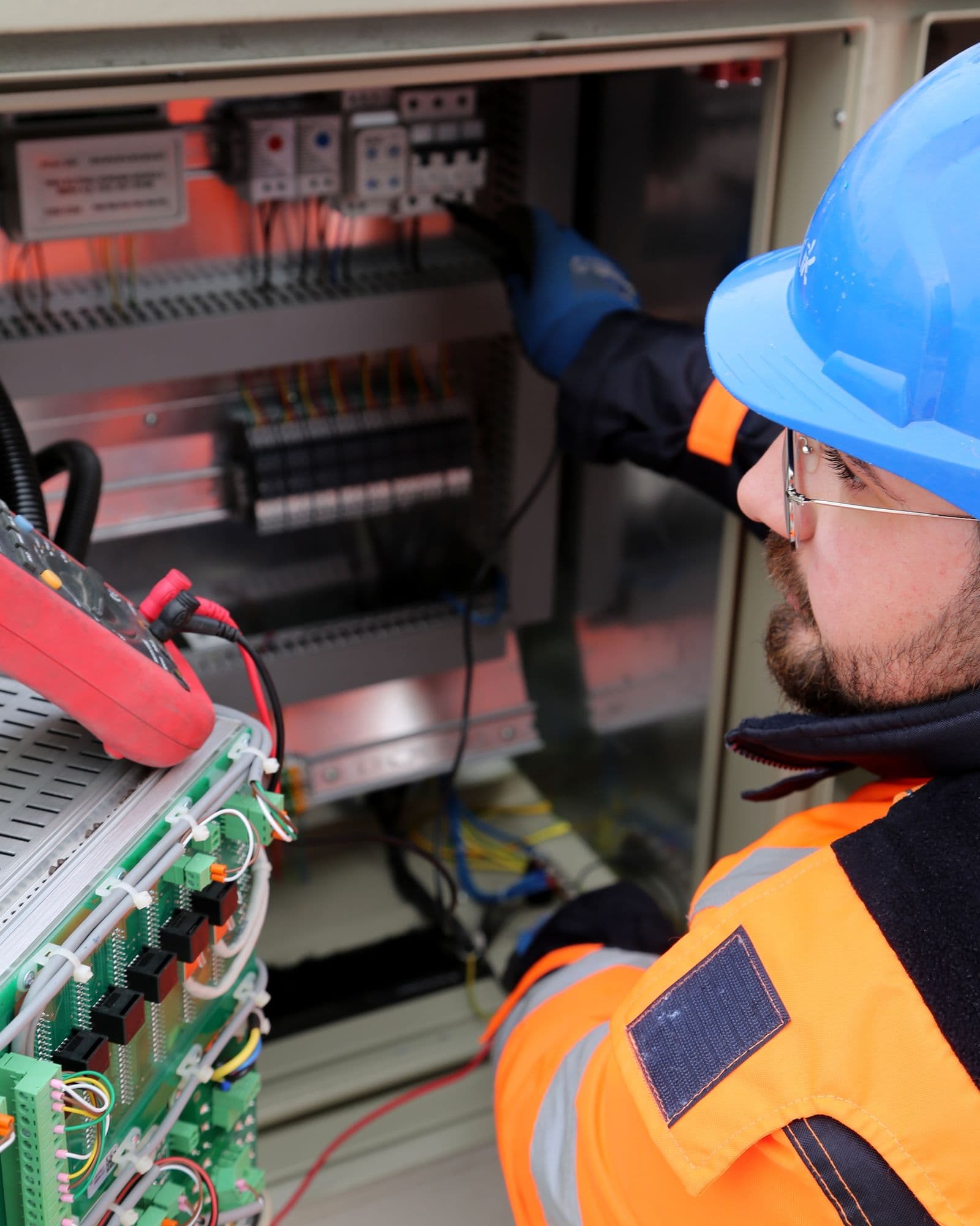 An ICPE engineer testing terminations at a control panel in the field.