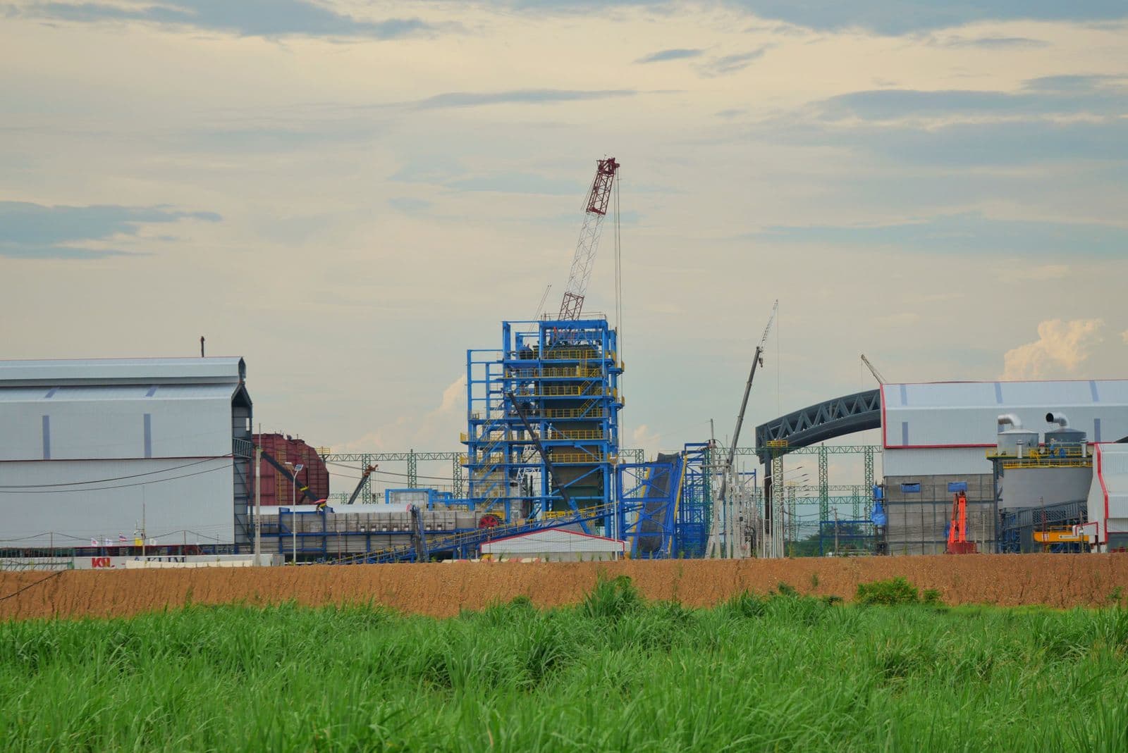 An industrial construction site in progress under multiple cranes.