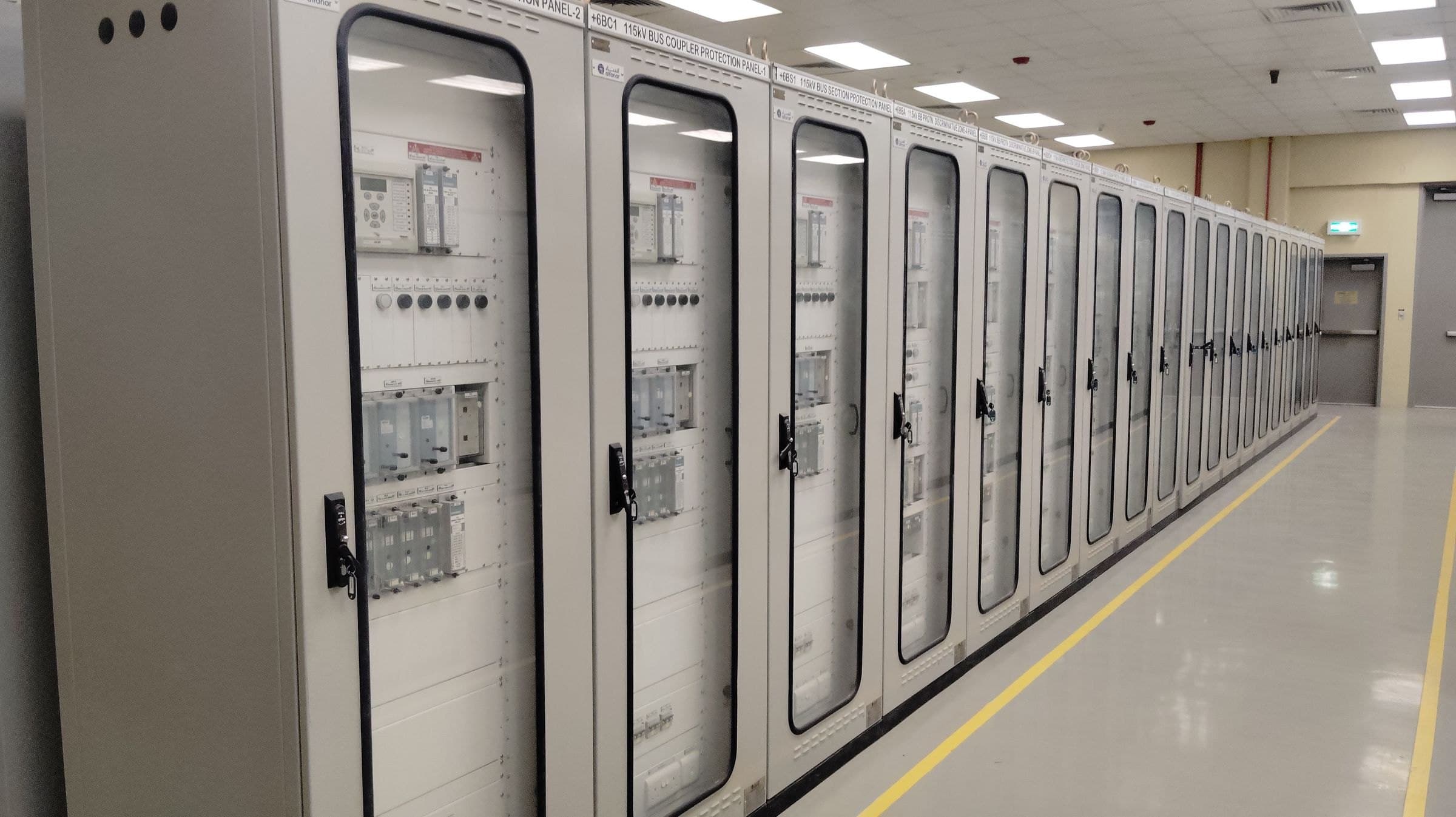 A row of protection and control panels in a substation relay room.