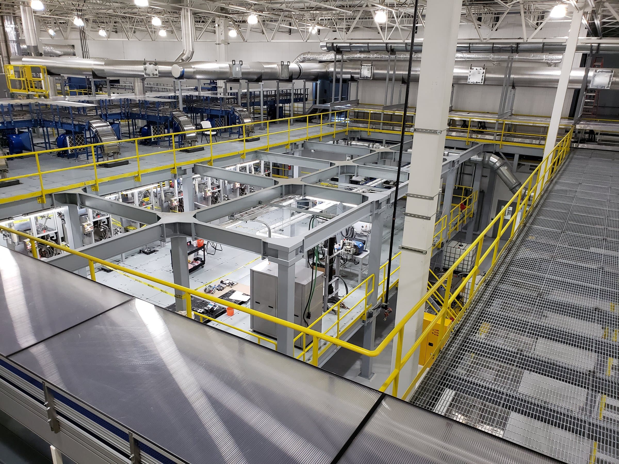 Structural steel mezzanine framing and platforms inside an industrial plant.
