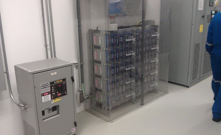 A battery rack and DC disconnect inside an electrical room.