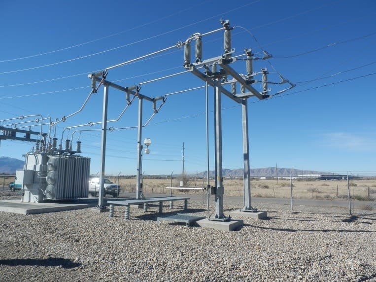 A substation switch structure and transformer on a gravel pad.