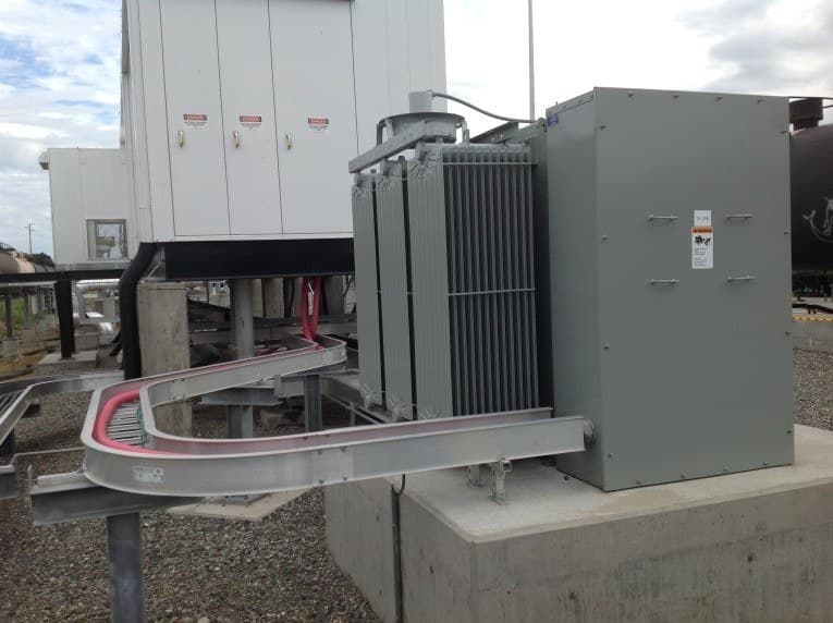 A pad-mounted transformer connected to a prefabricated building by bus duct.